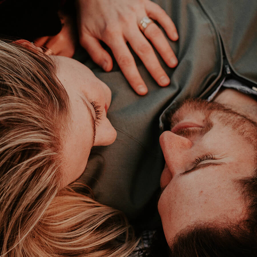 young couple laying down and staring into each other's eyes